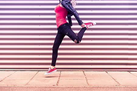 Young Happy Woman Jumping in Front of Metal Wall thumbnail