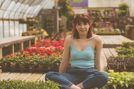 woman sitting on ground near green plants thumbnail