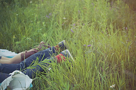 man wearing blue jeans laying near grass thumbnail