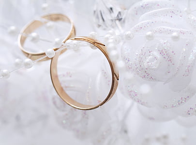 pair of gold-colored bangle bracelets near flower decor thumbnail