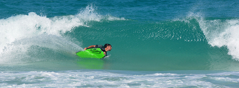 person swimming on waves during daytime thumbnail