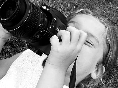 grayscale photo of girl using camera thumbnail