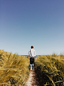 woman wearing white dress shirt and blue jeans on grass during daytime thumbnail