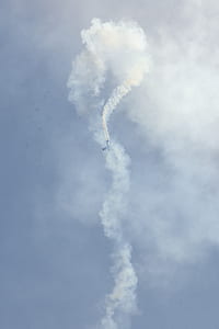 aerobatic plane covered with contrails thumbnail