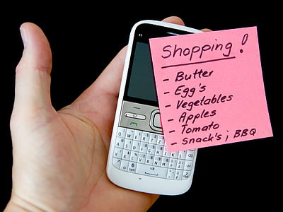 person holding QWERTY phone and pink card thumbnail