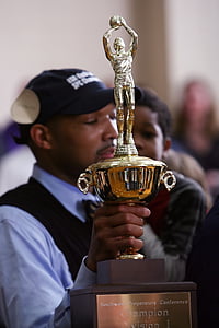 person holding trophy thumbnail