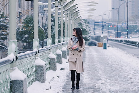 woman walking on road covered with snow thumbnail