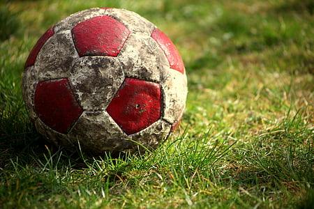 white and red soccer ball on green grass thumbnail
