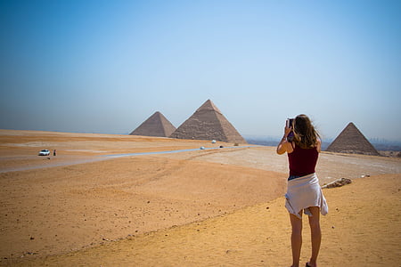 woman wearing red tank top standing looking on brown field during daytime thumbnail