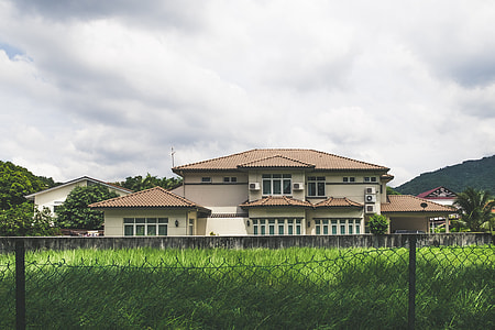 white and brown house under cloudy sky thumbnail