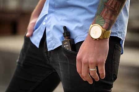 man wearing black bottoms with black e-juice bottle on left pocket thumbnail