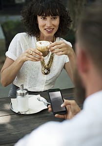 woman in white top holding clear drinking glass thumbnail