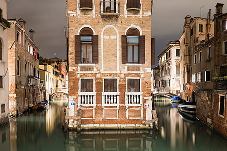 photo of brown and white painted building near body of water thumbnail