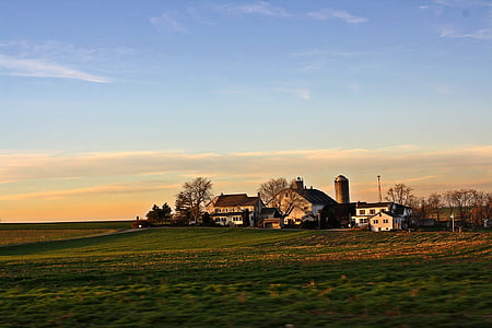 landscape photography of field with white buildings at daytime thumbnail