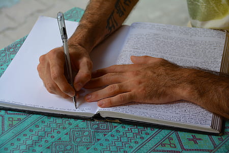 person writing on white paper thumbnail