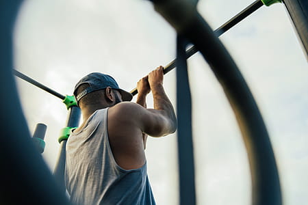 A young african man doing chin-up exercise outdoors thumbnail