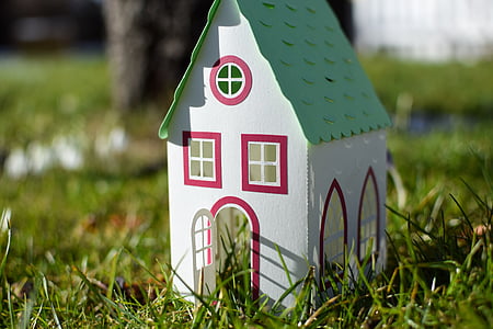 white and green wooden mini house on green grass thumbnail