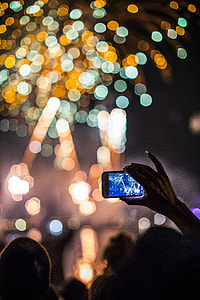 selective focus photography of person taking photo of fireworks display thumbnail