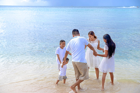 family holding hands circle on seashore at day time thumbnail