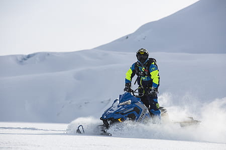 Person Rides on Blue Snowmobile at Daytime thumbnail