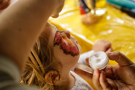 person pouring white glitter on girl's face thumbnail
