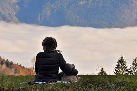 woman sitting on green grass field during daytime thumbnail