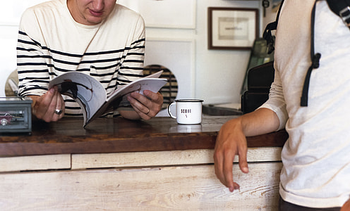 person wearing white and black striped shirt reading book thumbnail