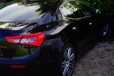 black sedan parked by the green tree thumbnail