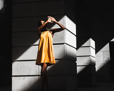 woman wearing yellow mini dress on grey concrete post thumbnail