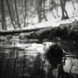 grayscale photo of woman bathing on body of water thumbnail