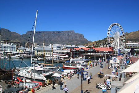 people walking near body of water with boats during daytime thumbnail