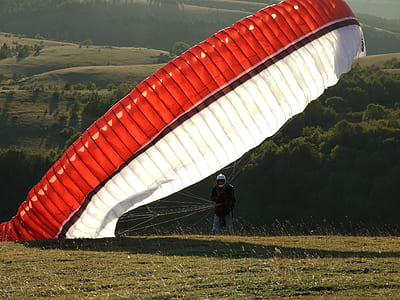 Man on the Ground With a Red Black and White Parachute thumbnail
