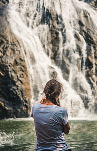 woman in white shirt facing waterfalls thumbnail