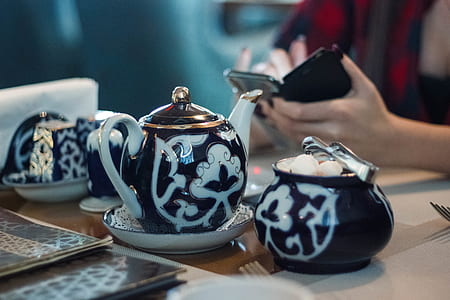 white and black ceramic teapot on table thumbnail