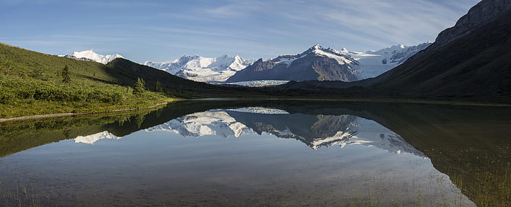 body of water near glacier mountain at daytime thumbnail