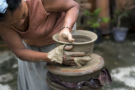 woman making clay pot at daytime thumbnail