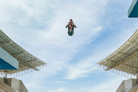 person in mid air performing stunts during daytime thumbnail