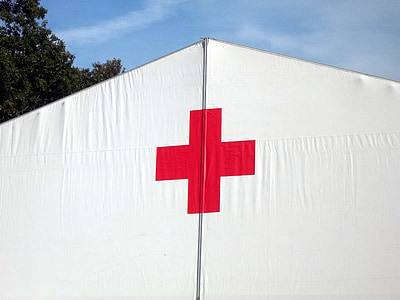 red cross print on white fabric under blue sky during daytime thumbnail
