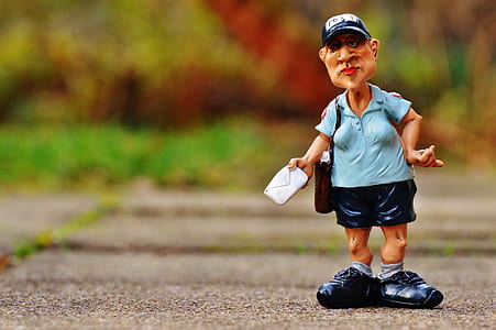 selective focus photo of man holding mail figurine thumbnail
