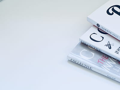 three magazines placed on white surface thumbnail