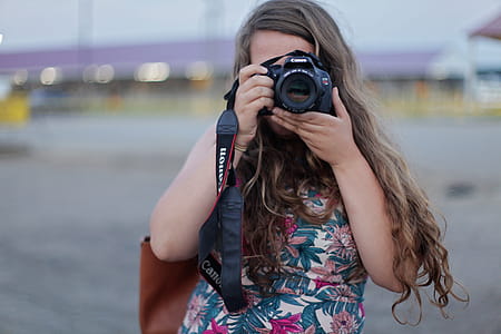 Woman Standing While Holding and Taking Picture from Canon Dslr Camera thumbnail