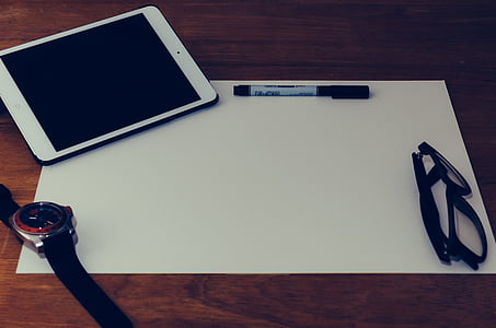 white iPad beside pen on white paper thumbnail