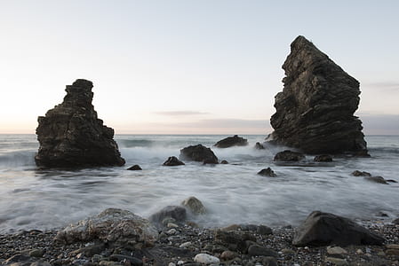 time lapse photography of body of water and rock formation thumbnail