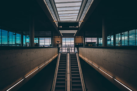 two escalators leading to doorway inside concrete building thumbnail