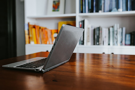 Silver laptop with various items on a table thumbnail