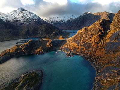 landscape photo of brown mountains and body of water at daytime thumbnail