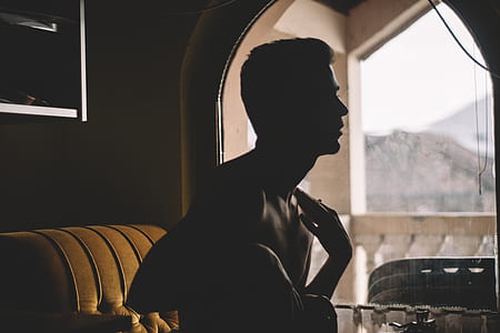 topless man standing beside of glass window during daytime thumbnail