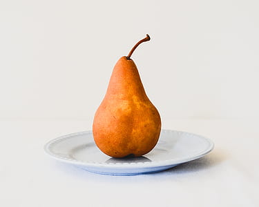 brown pear on white ceramic saucer thumbnail