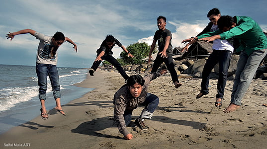 six person doing stunt on sea shore during daytime thumbnail