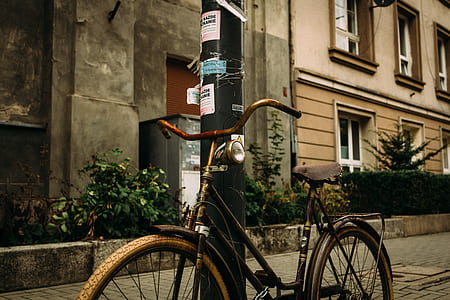 black and brown step-through bike leaning on black post thumbnail